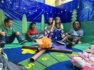 Teacher guiding a young child through a hands-on art and creative expression project in a Montessori-inspired preschool classroom