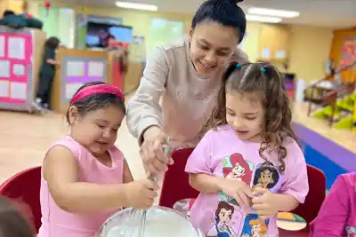 Teacher conducting individualized assessment and observation to create customized lesson plans for Pre-K child development at Sierra Preschool